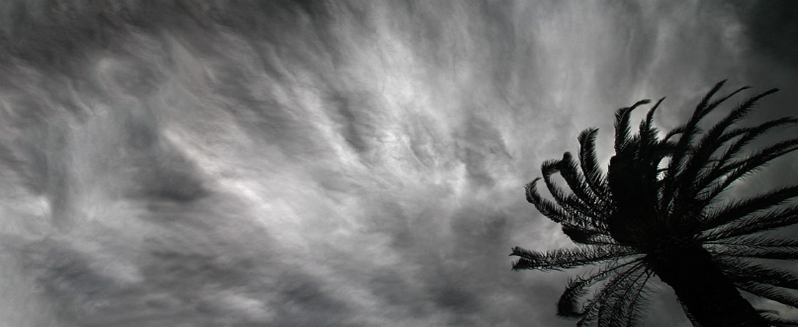 Sculpture d'un Ange tenant un globe terrestre illuminé sur ciel soleil couchant